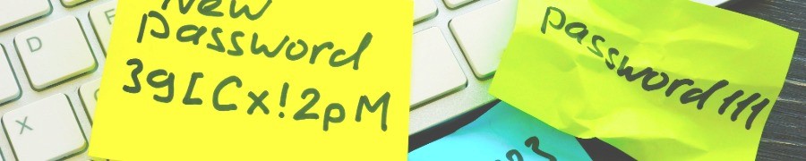 Yellow and green sticky notes with handwritten passwords stuck on a computer keyboard