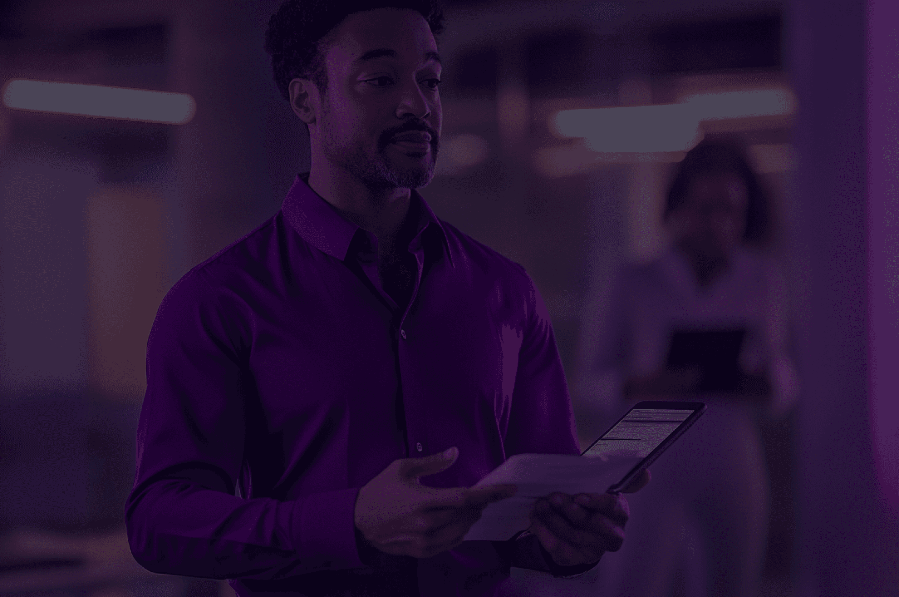 Homen segurando um tablet e folhas