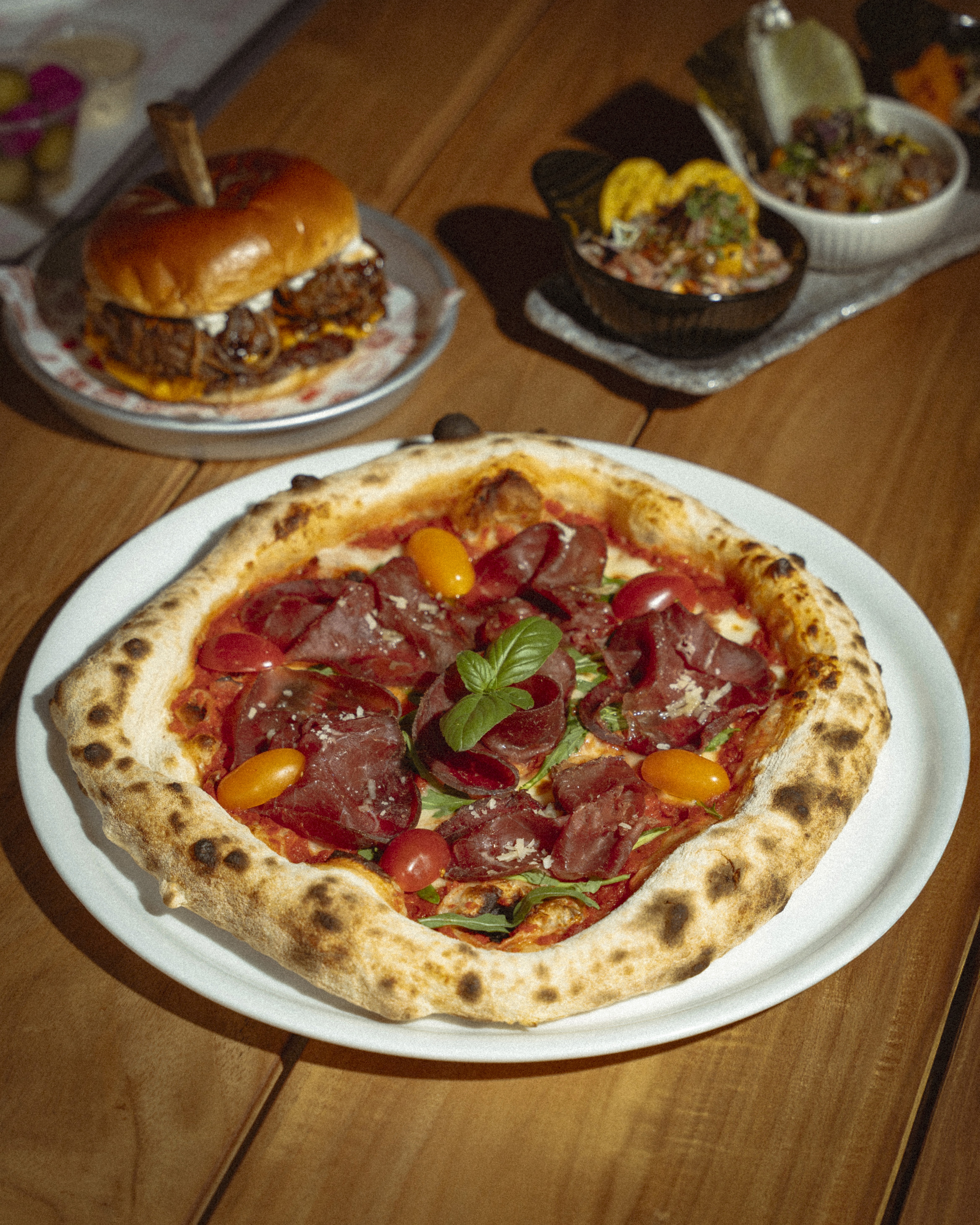 A delicious pizza in Dubai at Social Distrikt inside Dubai Mall, serving piping hot, crispy pizzas perfect for friends and family.