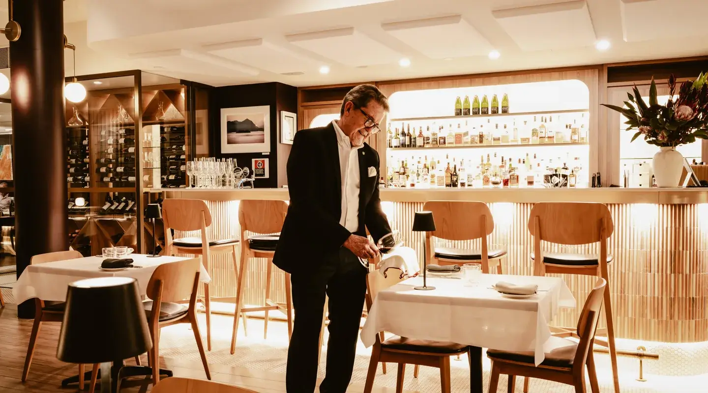 John Bligh polishing a wine glass at the ANNATA bar
