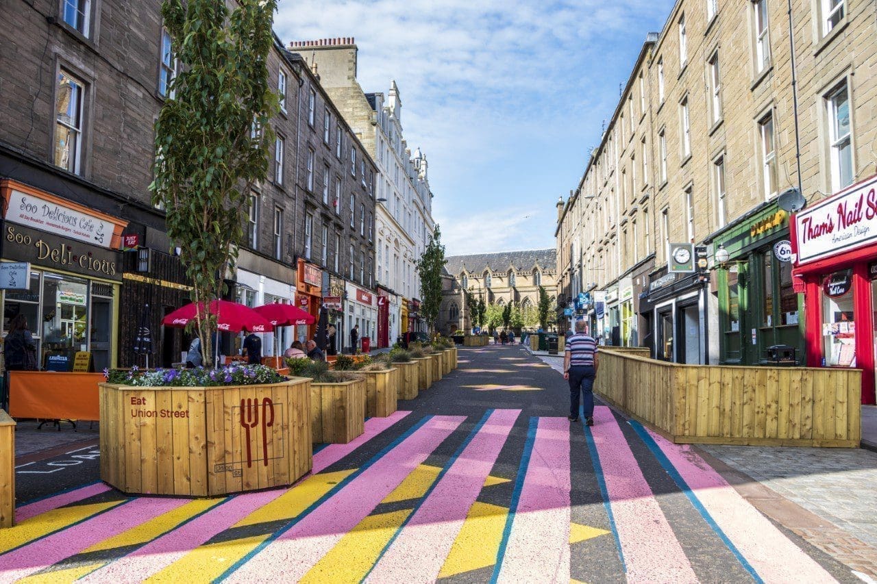 a group of people walking on a sidewalk
