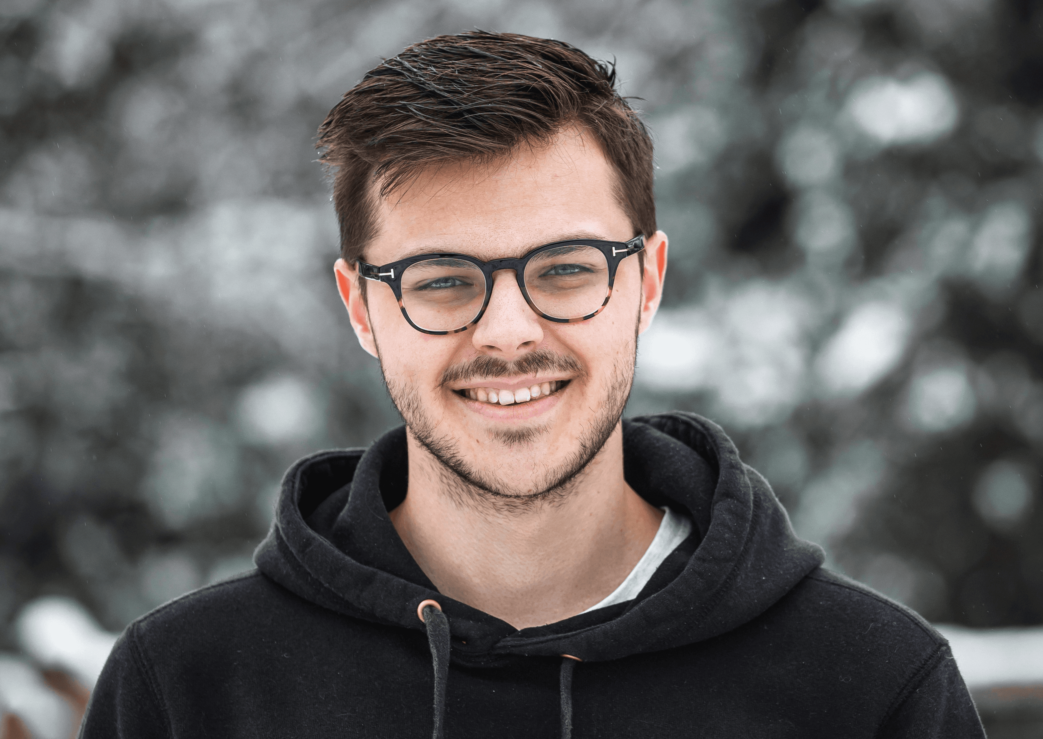 man in black hoodie wearing black framed eyeglasses