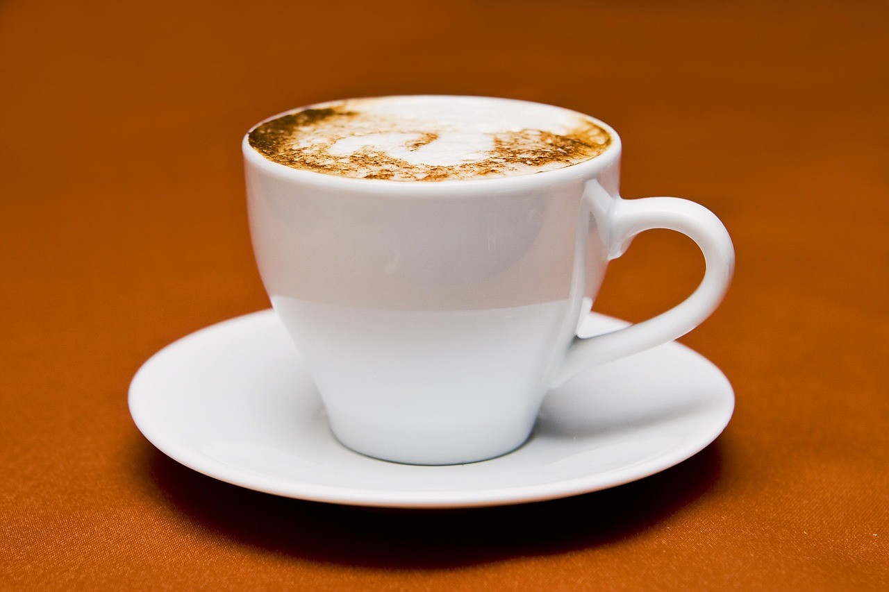 white ceramic cup with saucer and stainless steel spoon