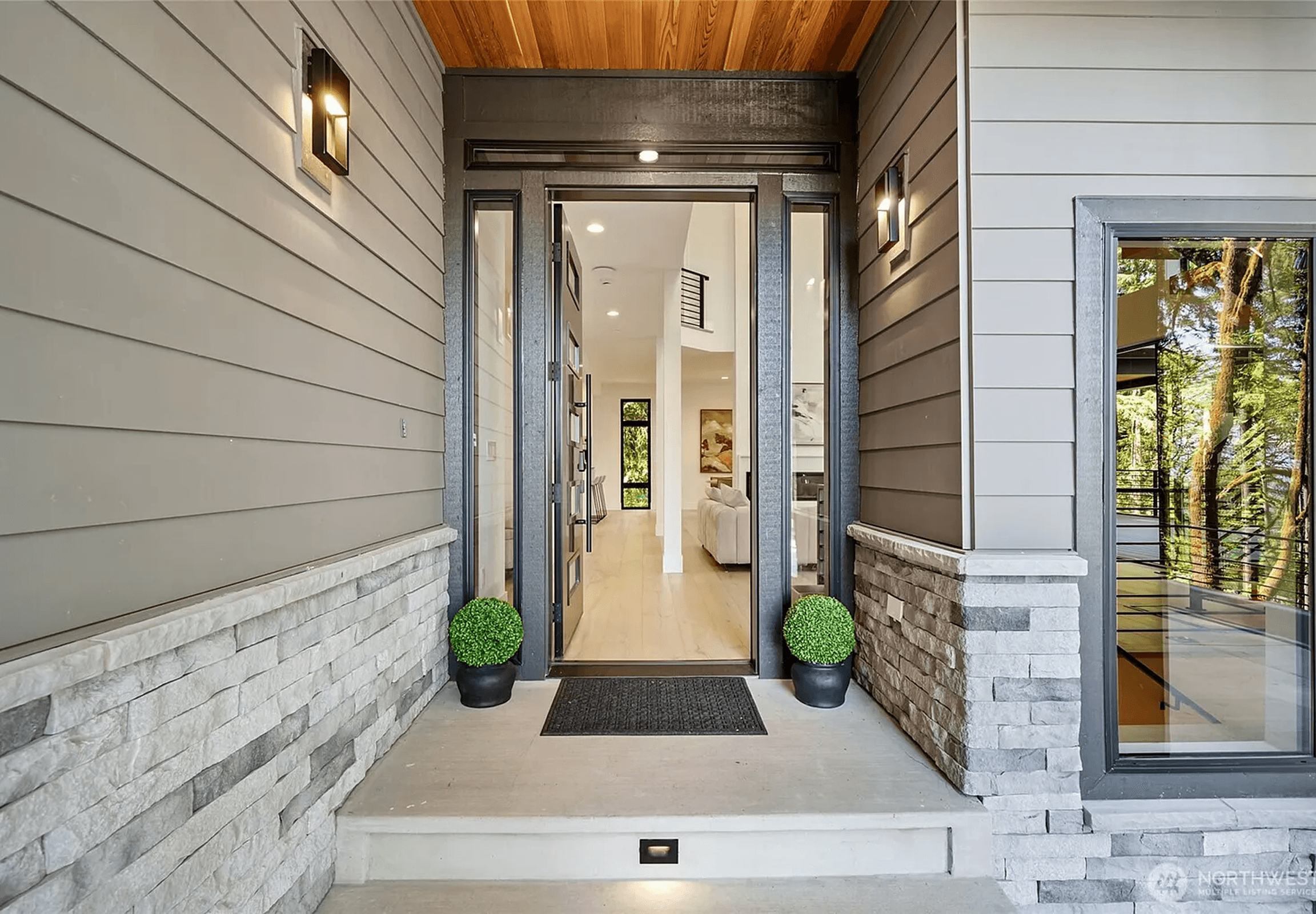 Interior corridor with wooden cladding, stone flooring, and diffused warm lighting Image