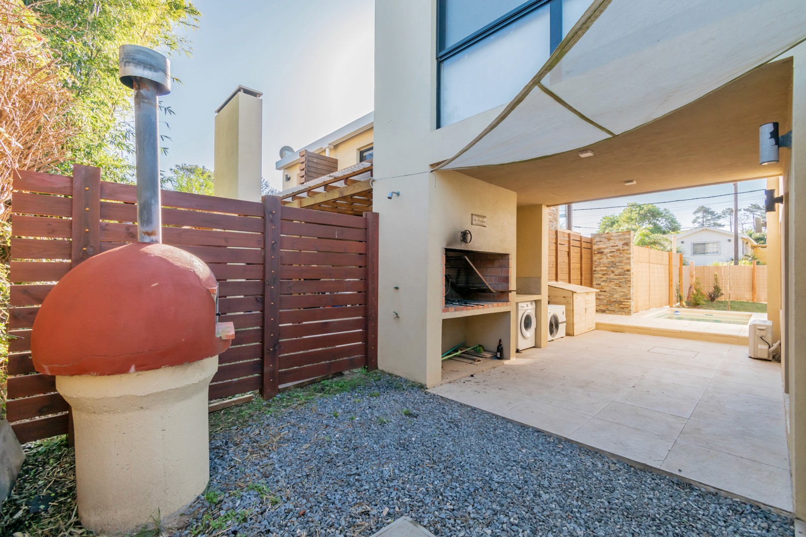 Parrillero techado en el patio trasero de Casa Horneros - espacio ideal para asados y reuniones al aire libre.