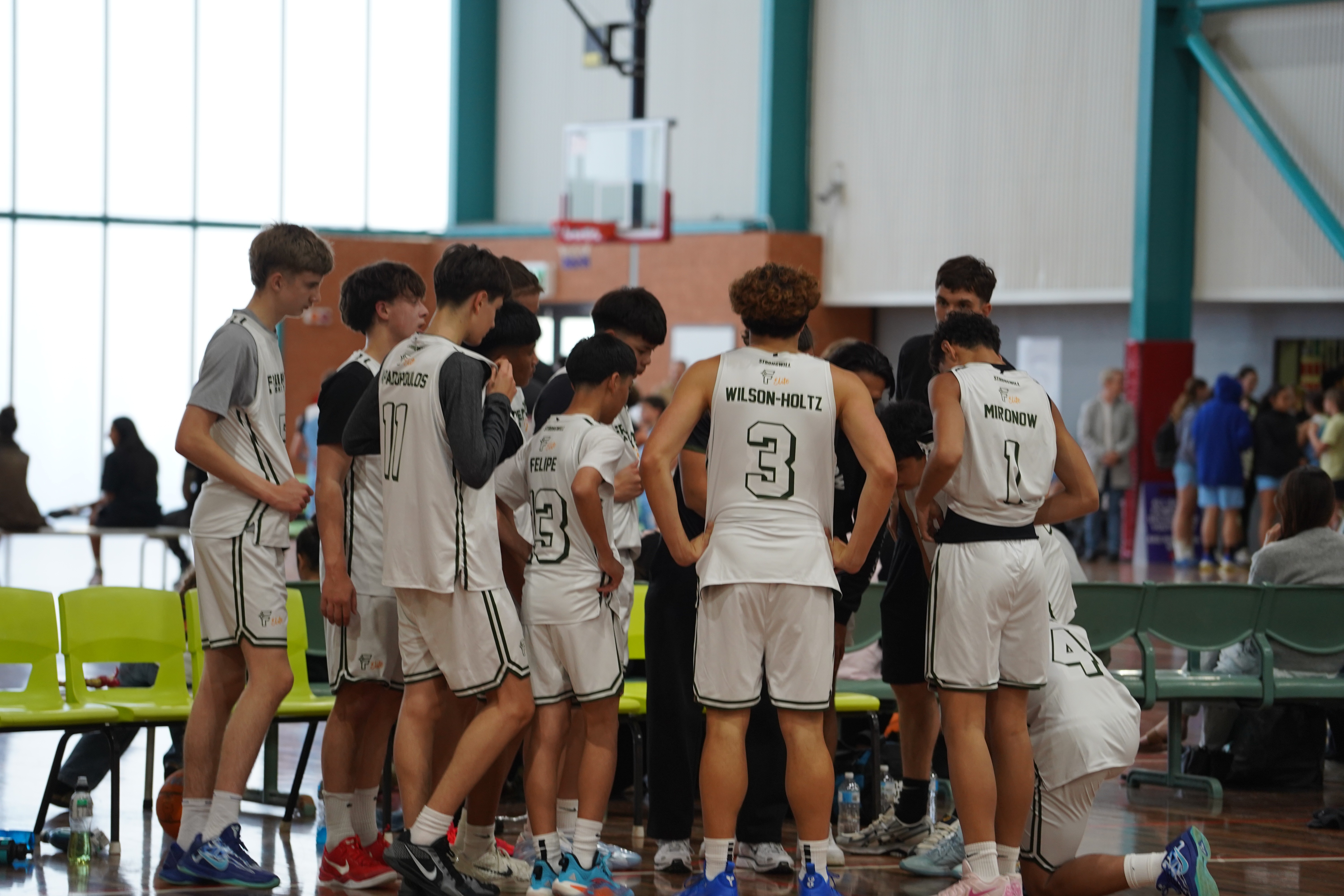 Intense Free Flow Basketball huddle engaging all the players and the three free flow coaches.