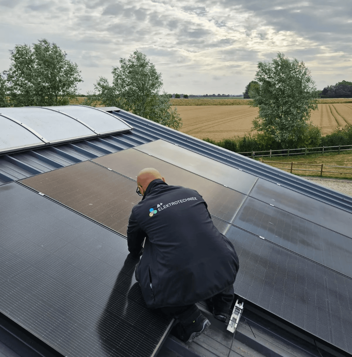 A+ Elektrotechniek medewerker monteert een zonnepaneel