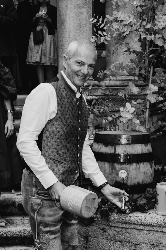 Person in traditional Bavarian attire opening a barrel