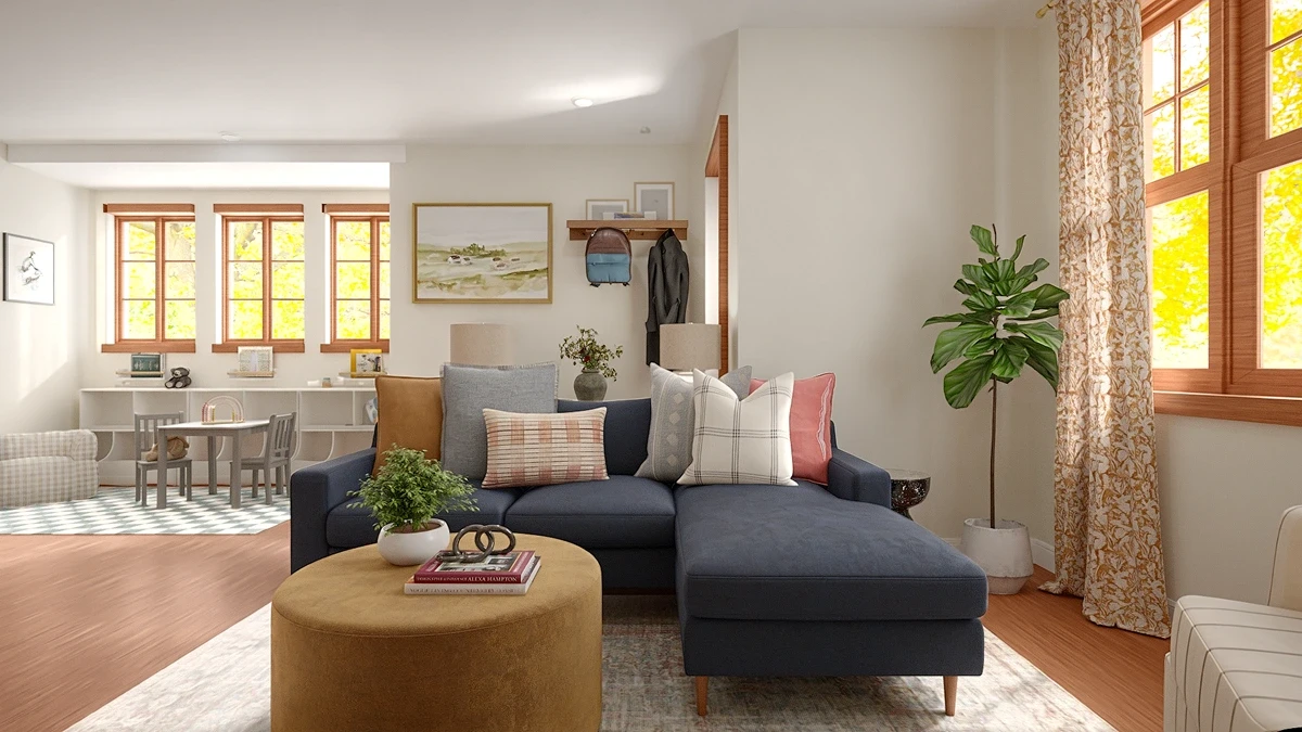 Family room with a navy sectional and mustard ottoman, with a kids' play area visible in the background.