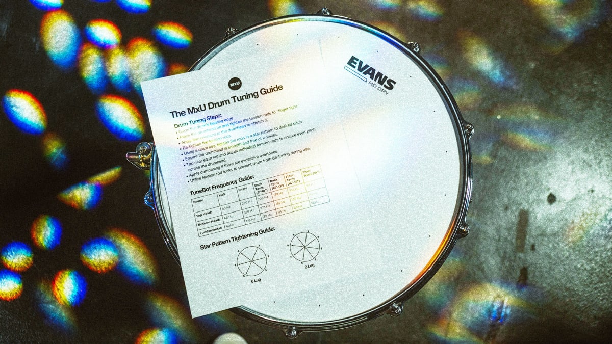 Cover for MxU's free resource 'Drum Tuning Guide': a printed guide rests on an Evans snare drum, surrounded by vibrant colorful reflections.