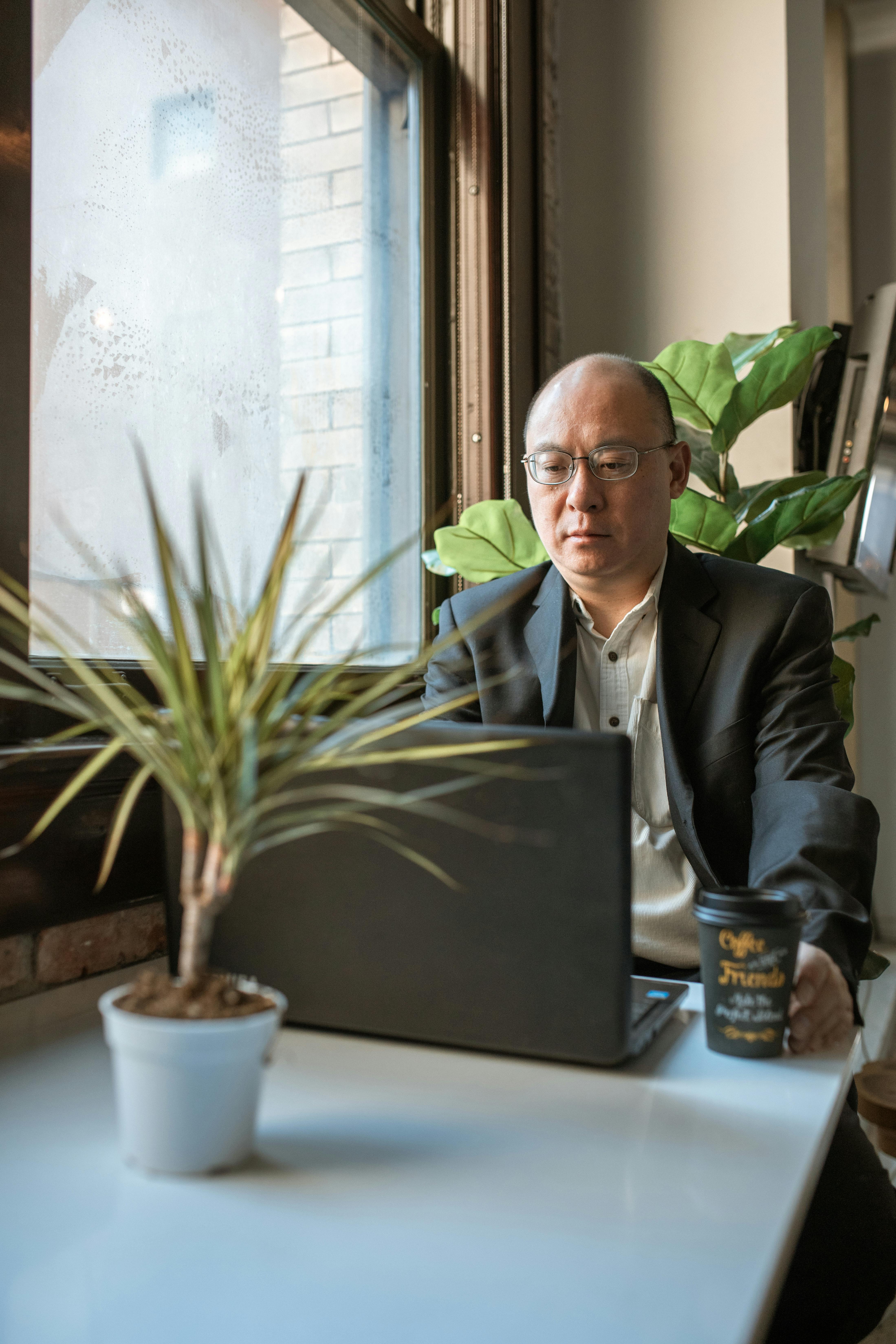 Professionista che lavora al computer in uno spazio moderno, rappresentazione di equilibrio e realizzazione dopo un percorso di coaching e career placement.