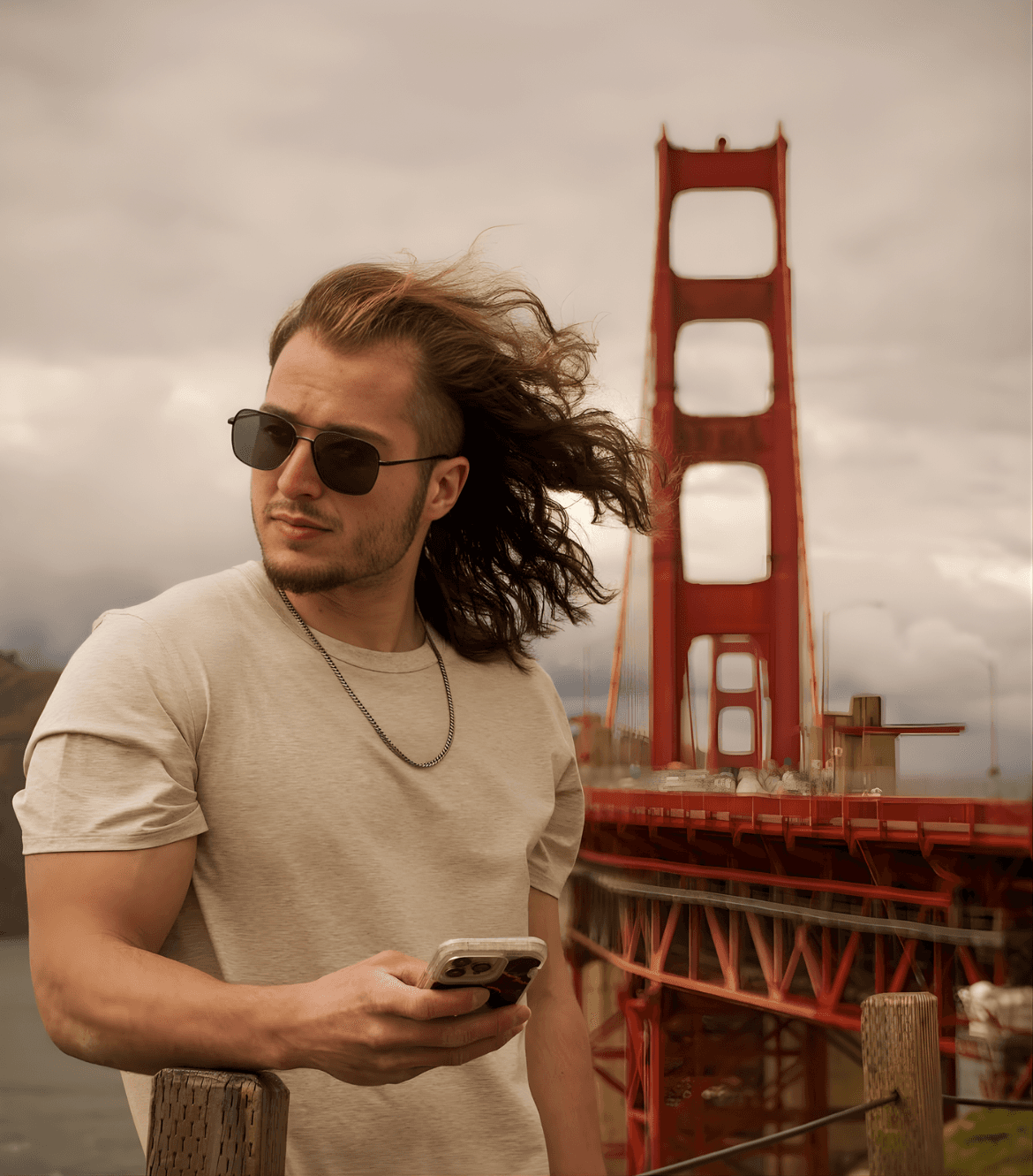A person with shoulder-length blonde hair wearing a black newsboy cap and a black sweater.