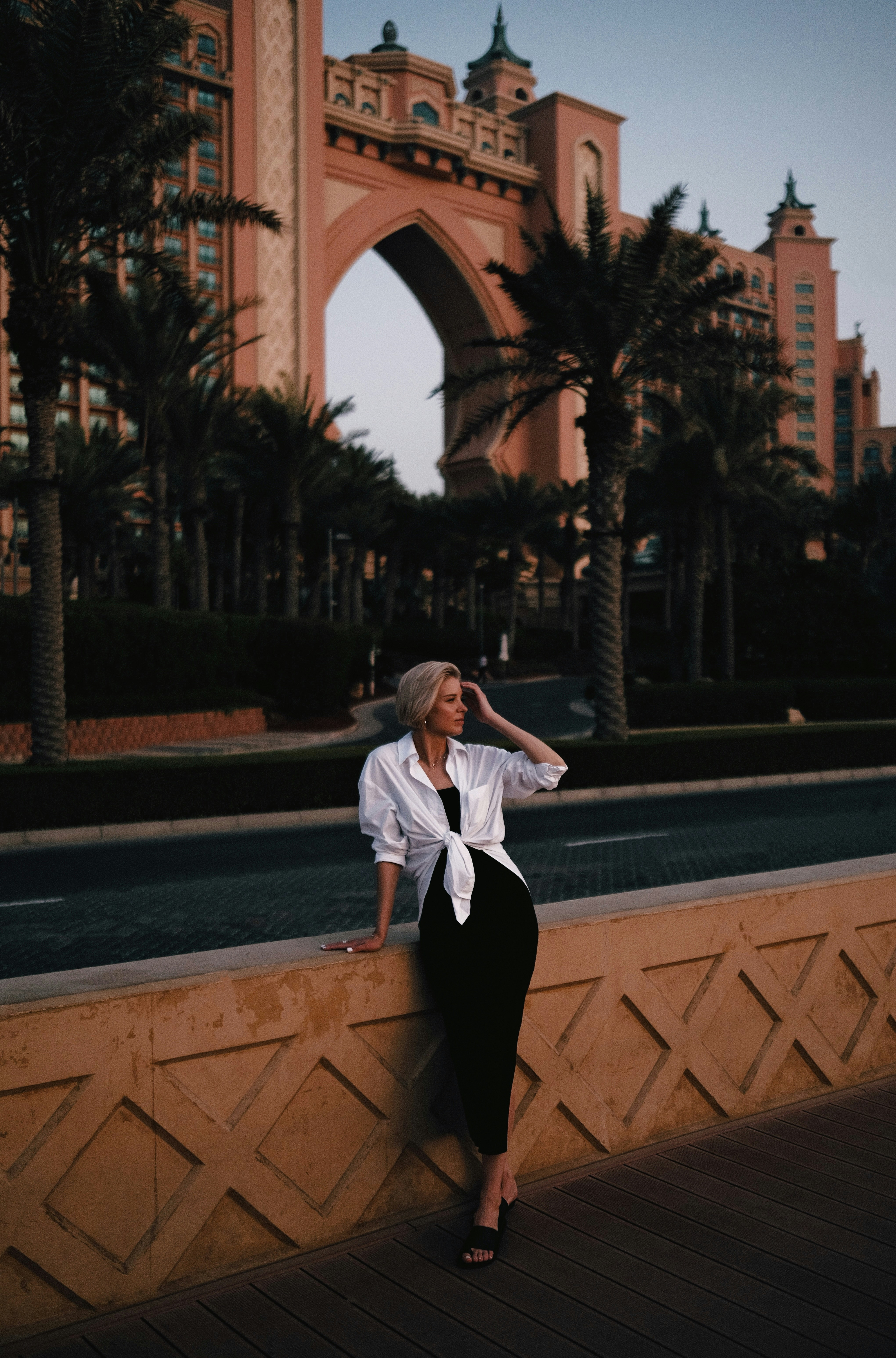 a woman leaning on a wall in front of a building