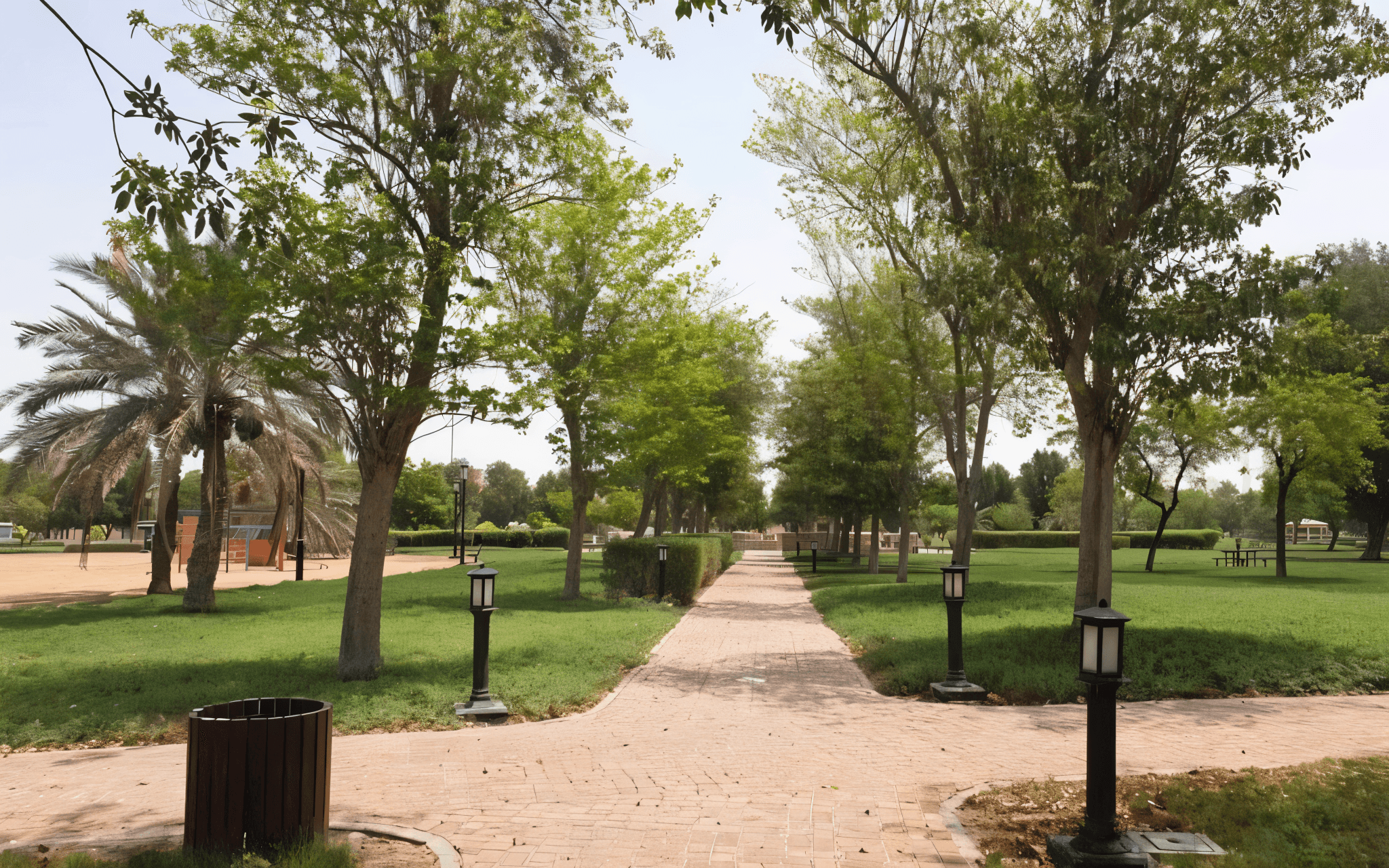 A park with trees and grass flanking both sides, located near Mazyad Mall.