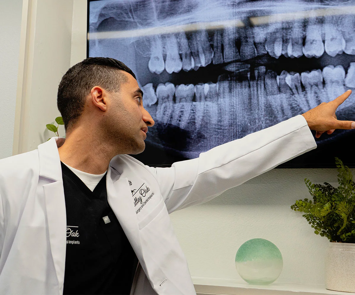 Dr. Justin Nassiri reviewing dental imaging and explaining treatment recommendations during a patient consultation at Valley Oak Oral Surgery.