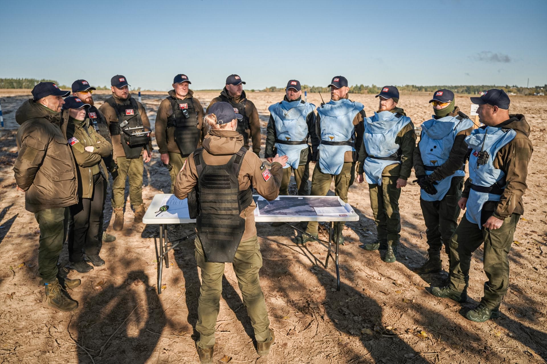GCS demining team receiving a field briefing during battle area clearance operations.