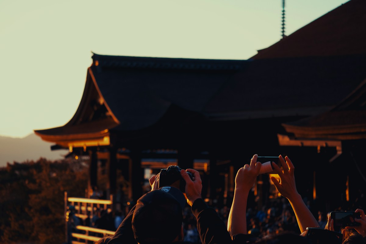 A traveler photographing a temple with a smartphone
