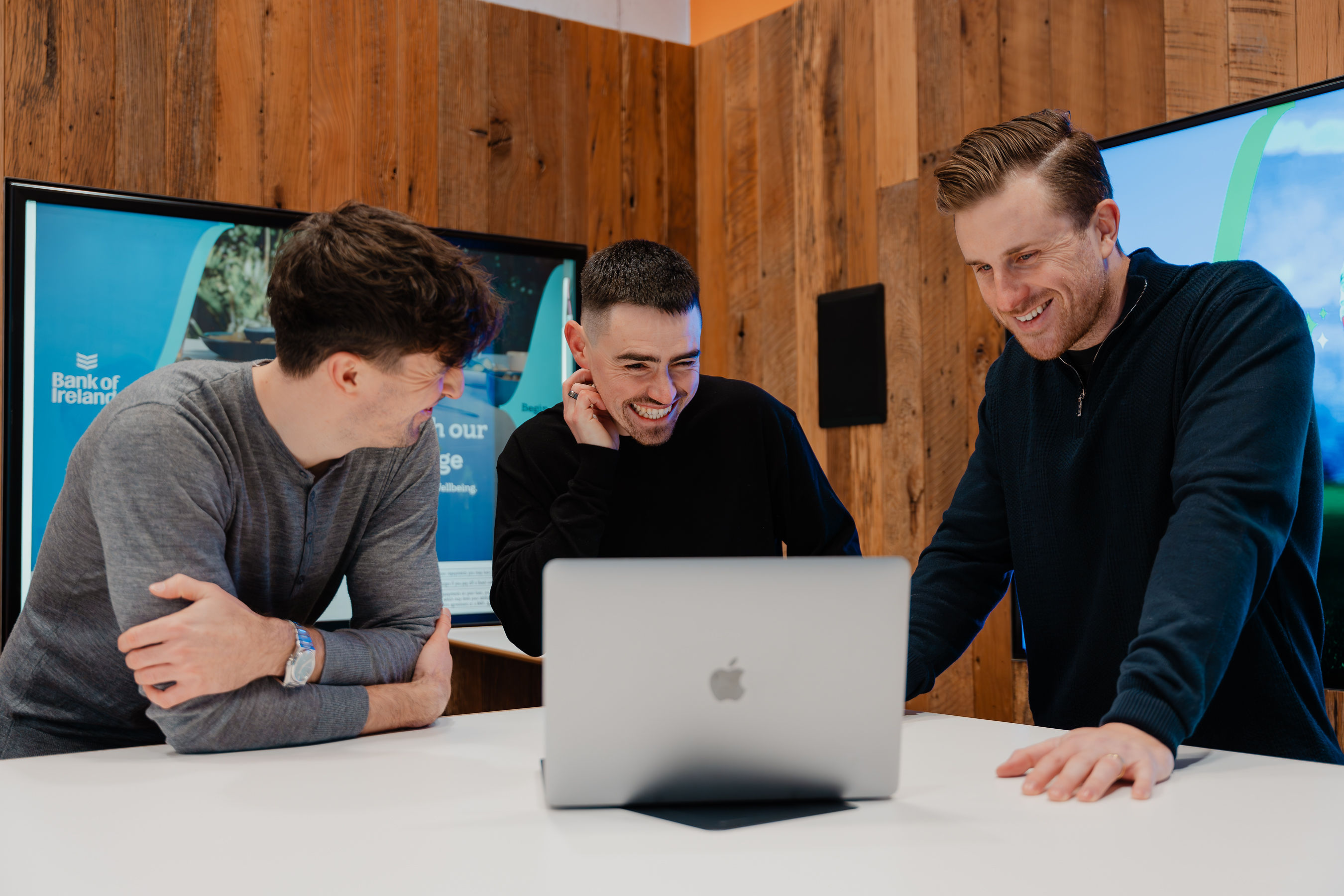 Team collaborating around a laptop, reflecting hands-on strategy consulting focused on solving commercial challenges and driving growth.