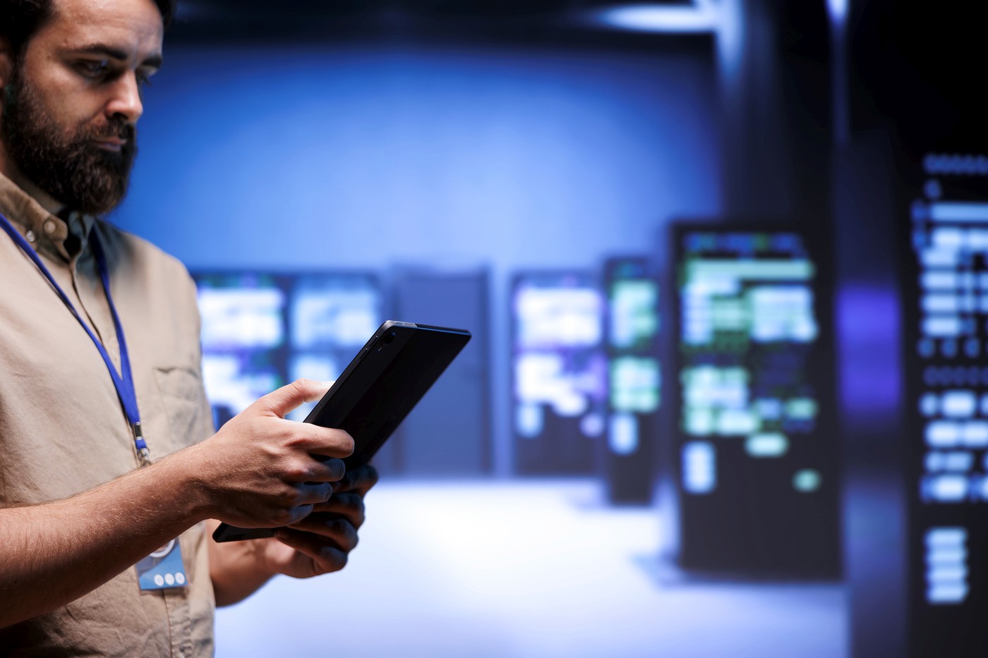 Profissional analisando dados em tablet dentro de um data center, representando a infraestrutura digital e conectividade tecnológica no Brasil.