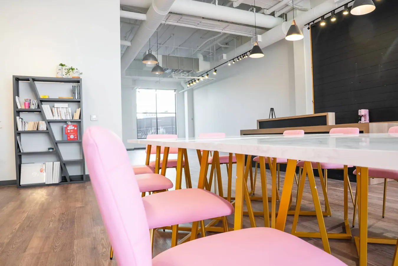 The Soulfully Wild studio, with a long table and soft pink chairs.