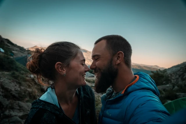 Neura Health Couple smiling close together outdoors at dusk in a rocky landscape.
