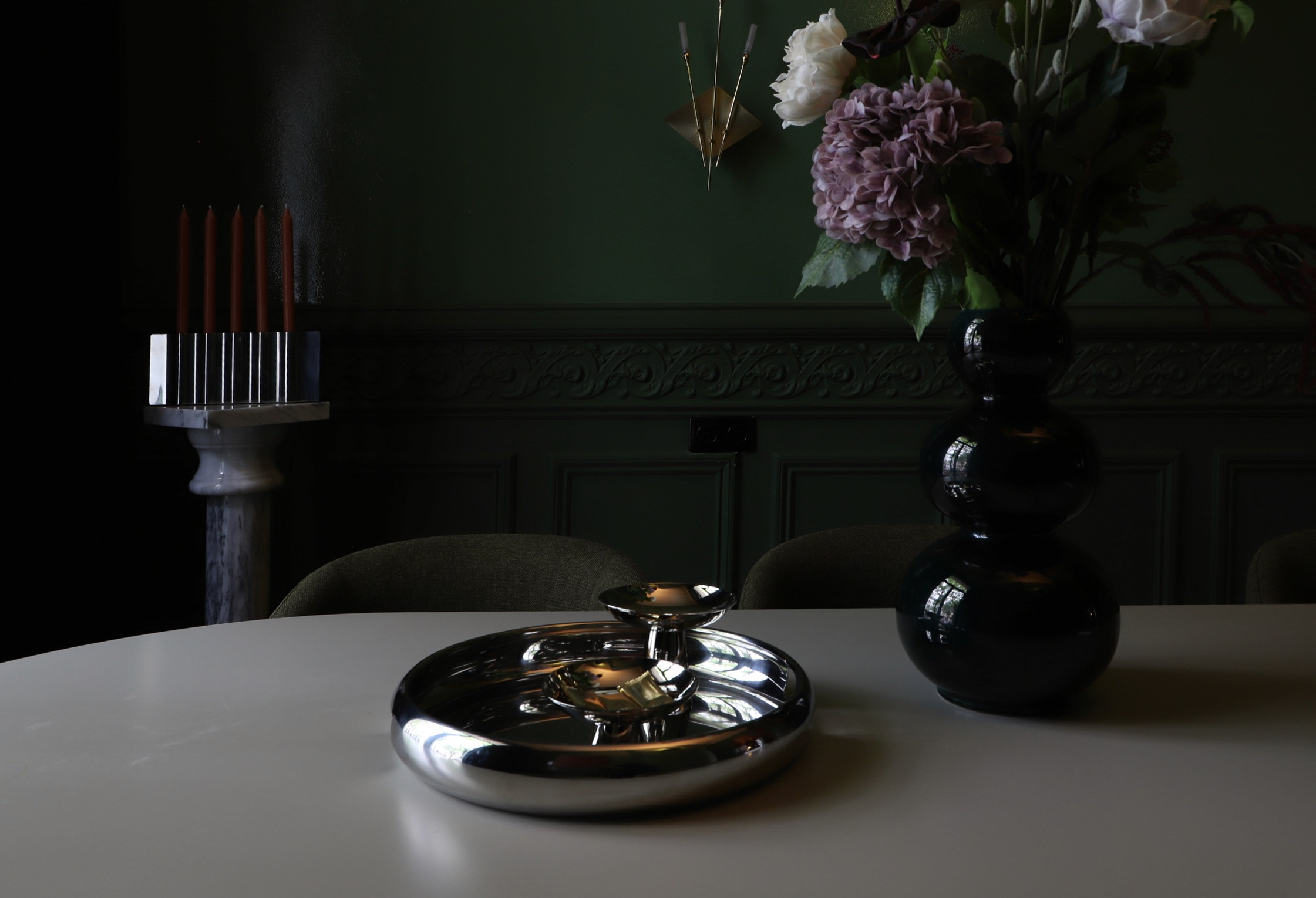 Moody green dining room with black ceramic vase and natural light — Belgian architecture studio ODA