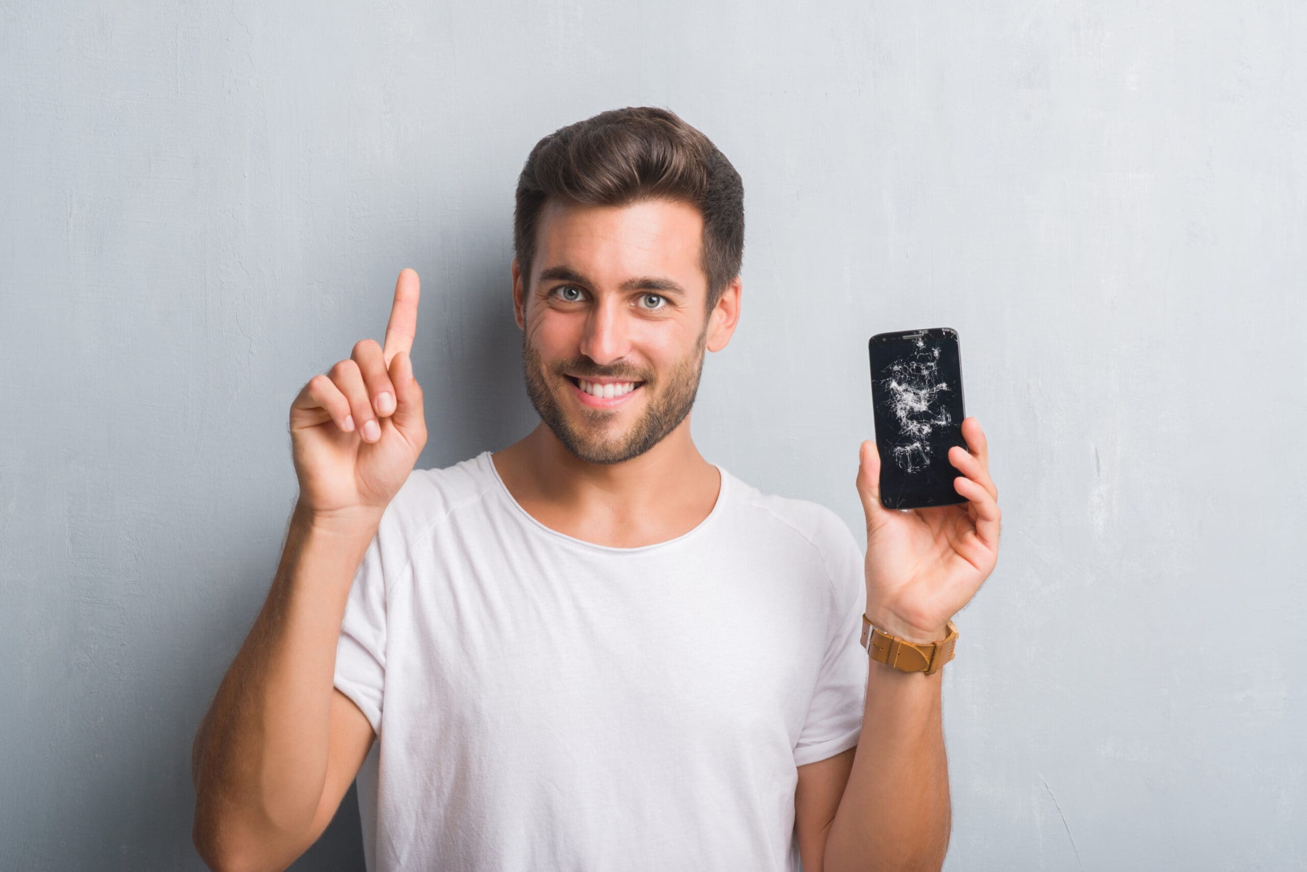 Young man with broken smartphone