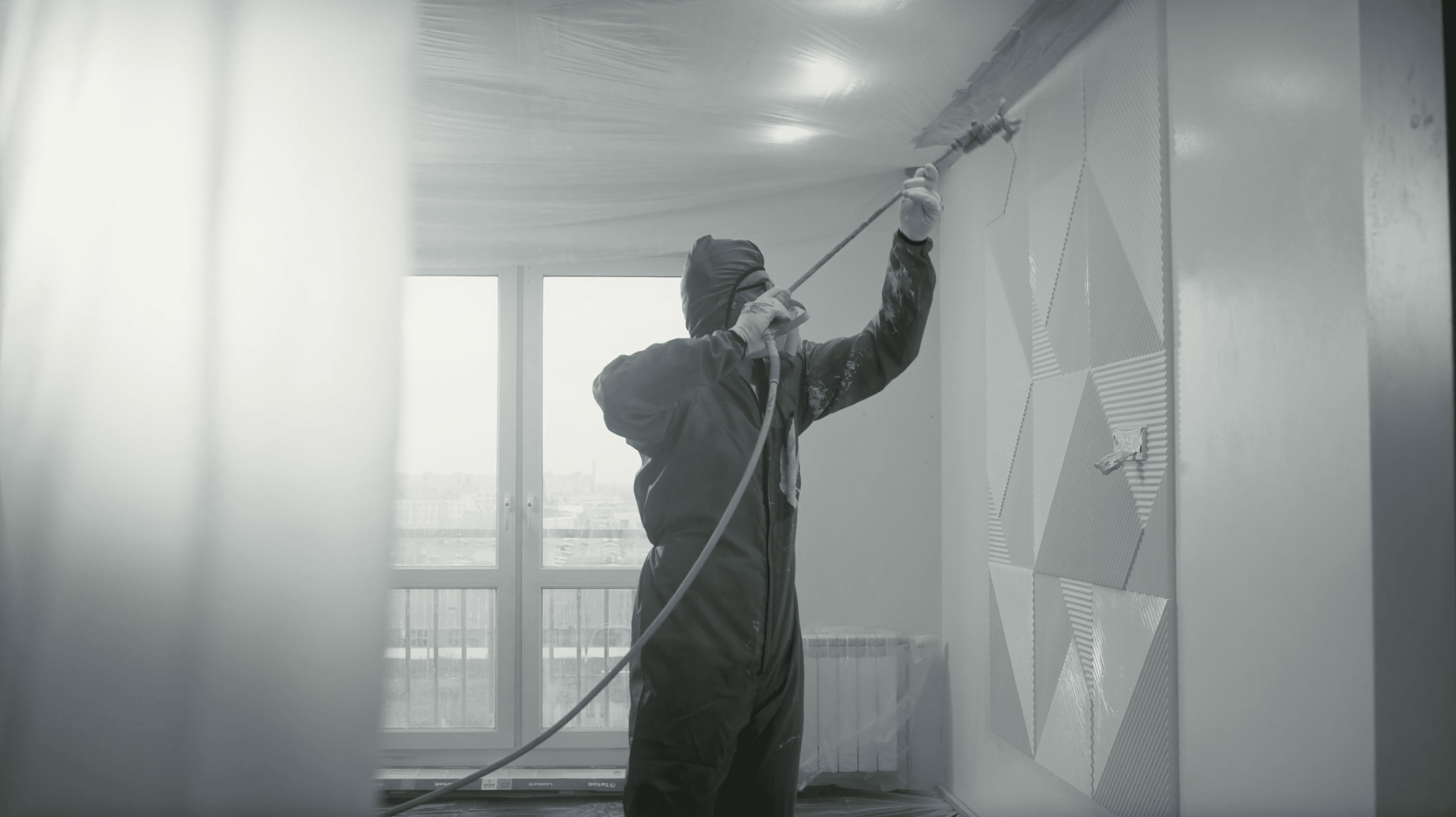 Couloir rénové : murs peints gris chaud, portes blanches, parquet en chevrons — peinture intérieure au Luxembourg.