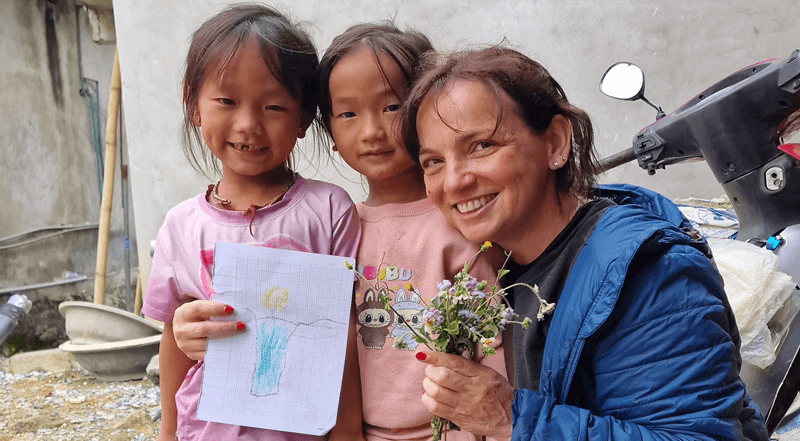 Marcia Rehem com criancás no Vietnam fazendo voluntariado