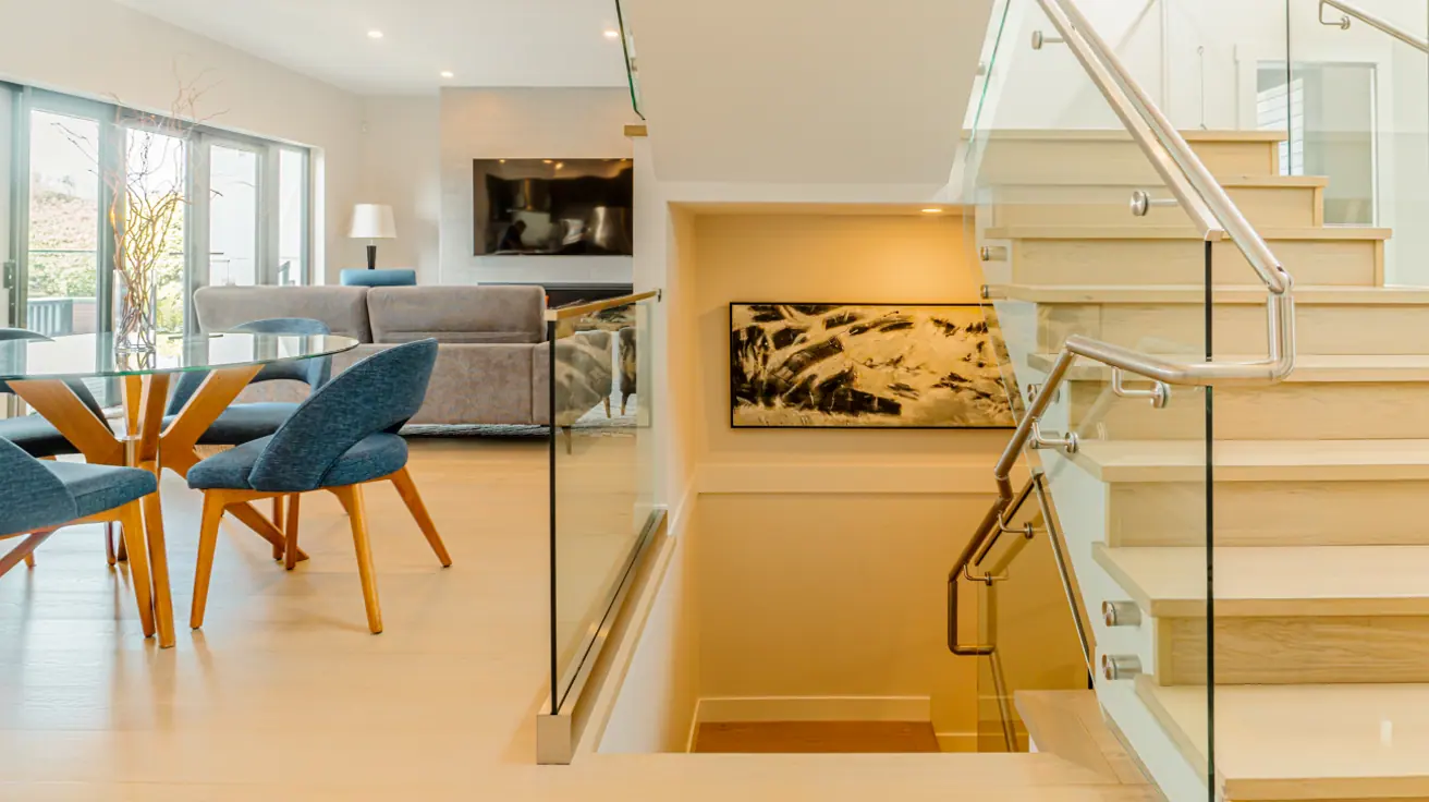 Modern glass staircase with wooden steps and sleek railings in custom-designed Burnaby home by Vancouver Custom Homes