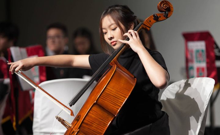 Two people installing or adjusting abstract blue artworks on a gallery wall 