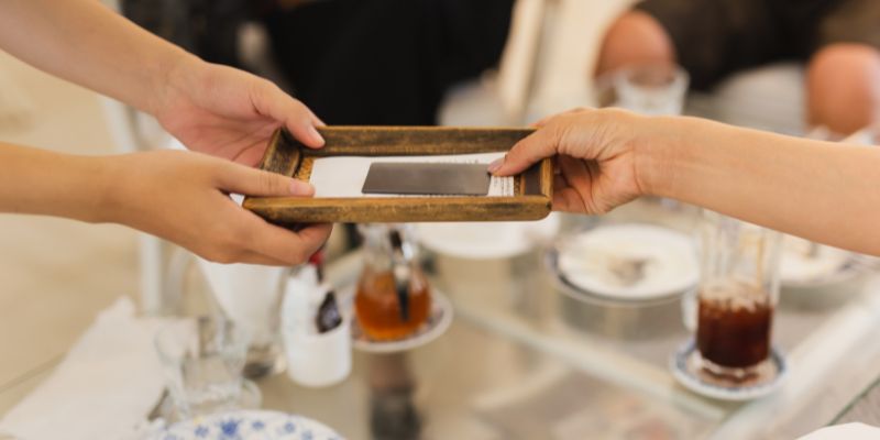 一名餐饮员工正在餐厅为顾客收款