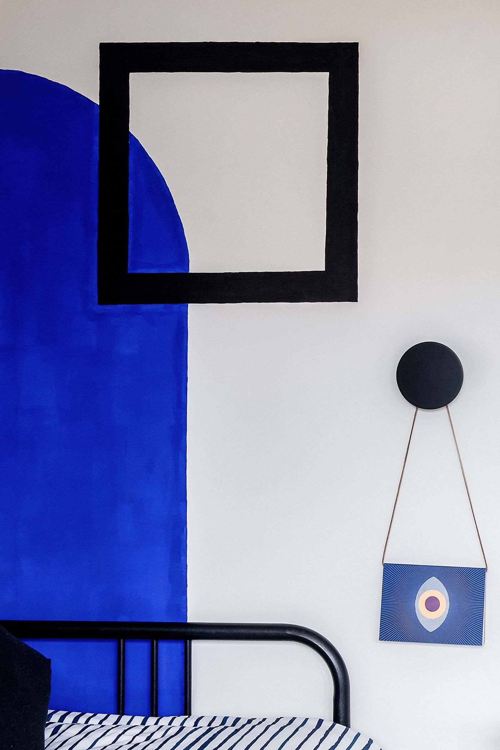 Close-up of vibrant cobalt blue paint detail on mural, transforming donated furniture into cohesive interior design, by Atelier Akuko