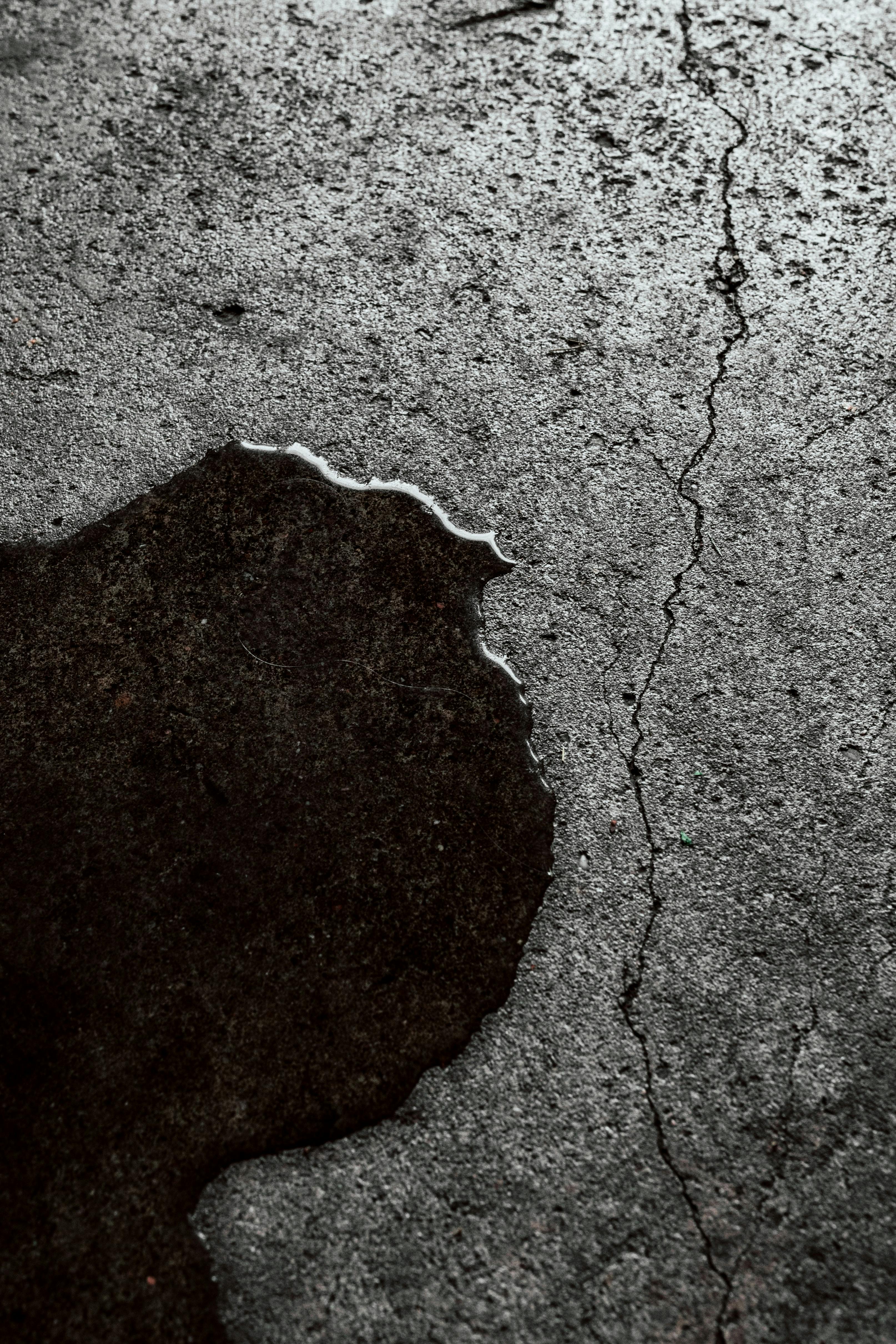 Modern glass and wood cabin with a cozy outdoor deck featuring wicker furniture, surrounded by lush green trees and a serene forest setting.