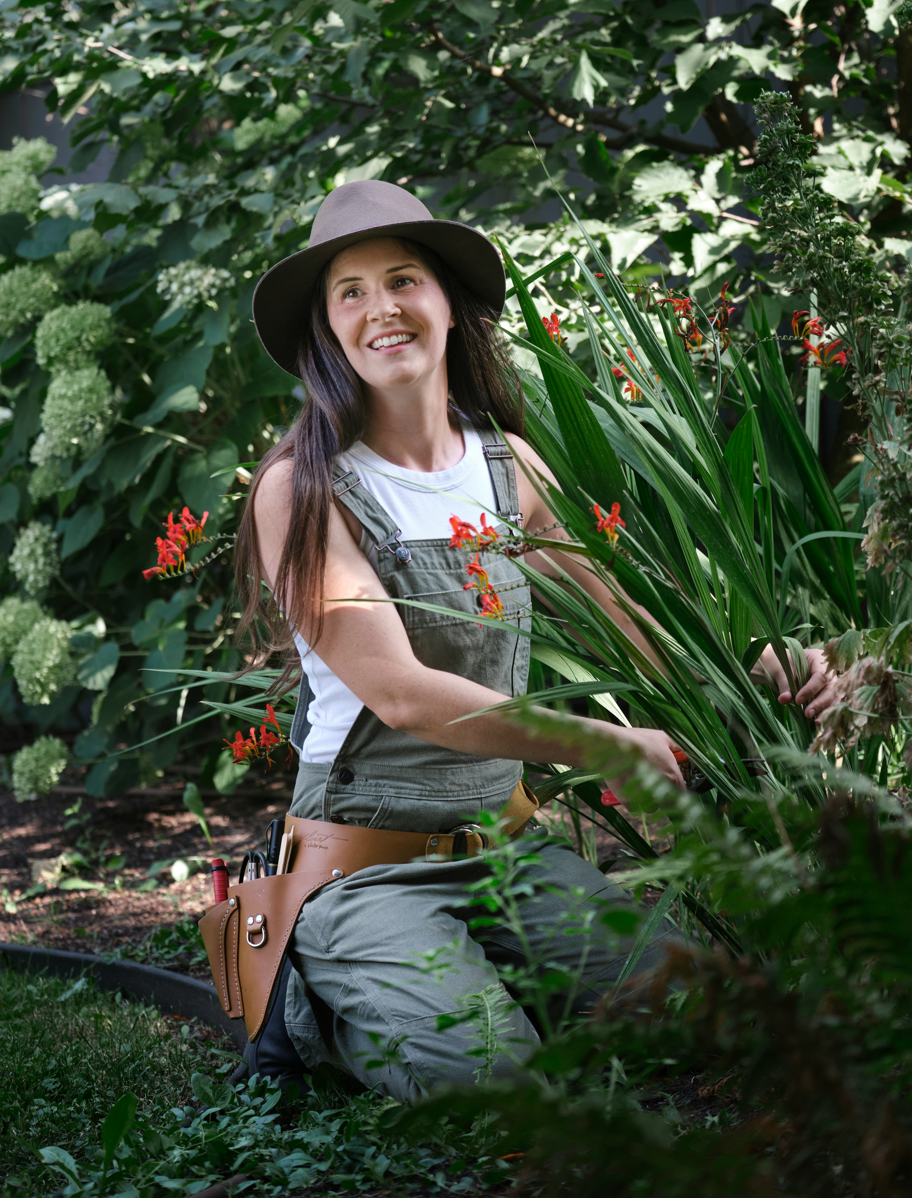 A woman sitting in a garden with a hat on