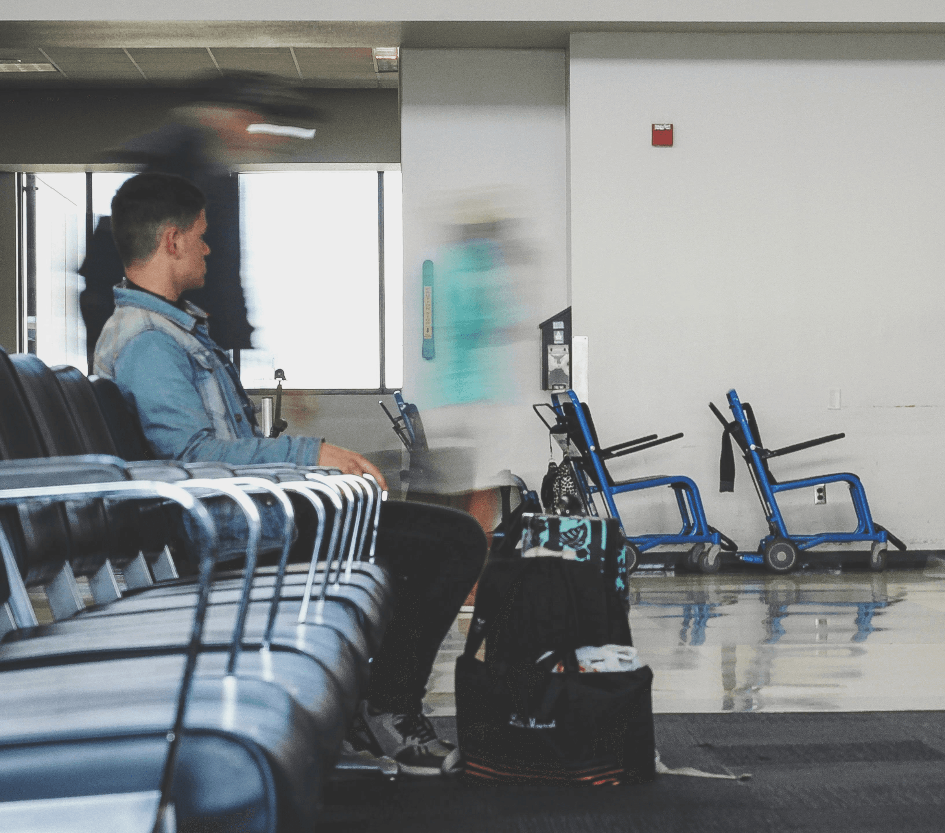 man sitting on chair watching female holding phone