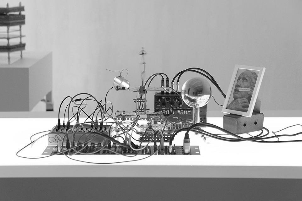 Black-and-white photograph of a tabletop electronic instrument assembled from modules, wires, and controls.