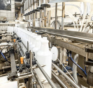 A detailed close-up view of an industrial bottling line in a factory setting.