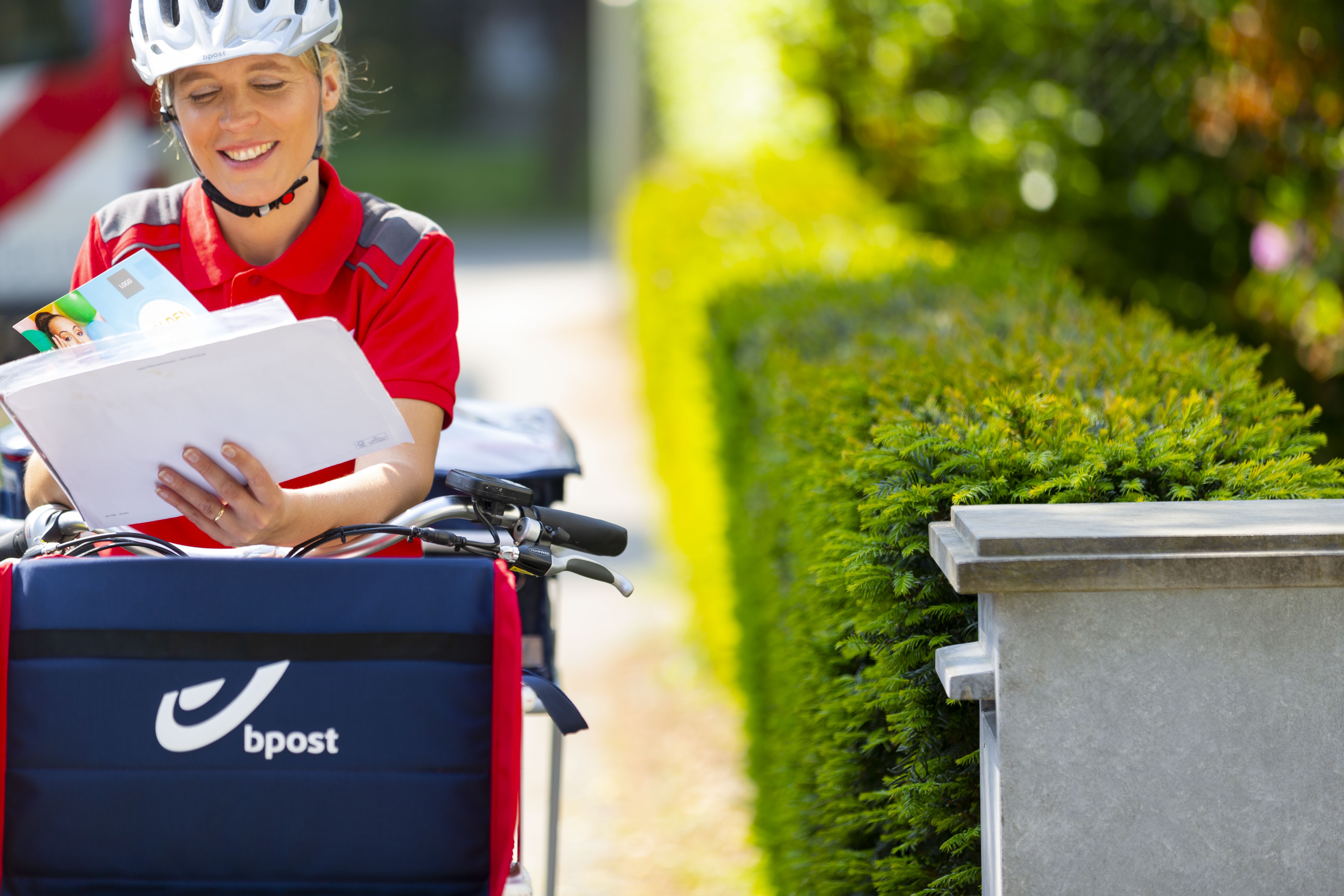 bpost dressed postwoman on a rebranded bike