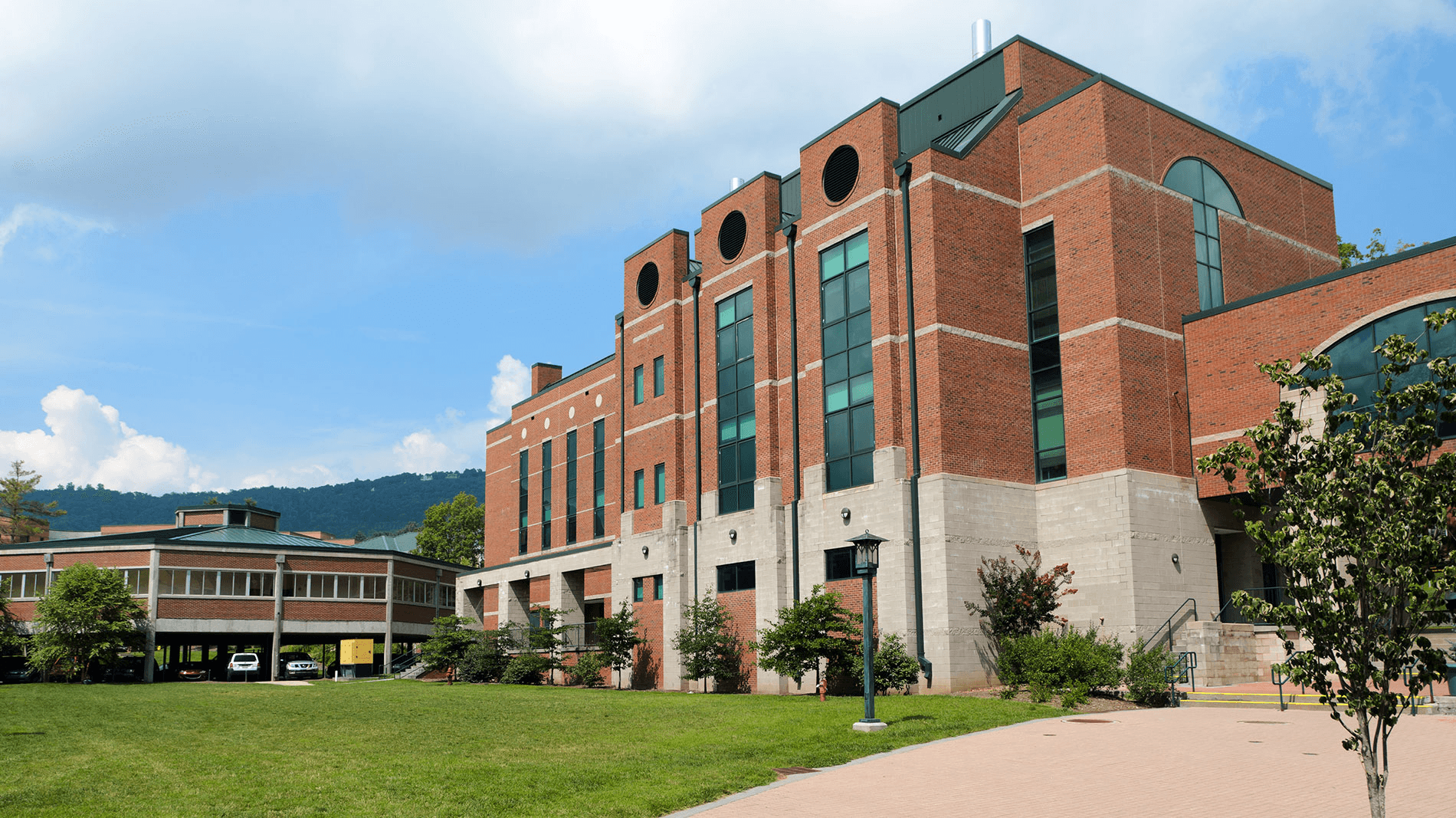 Man sitting in a dimly lit room, wearing a beige shirt and looking contemplative.