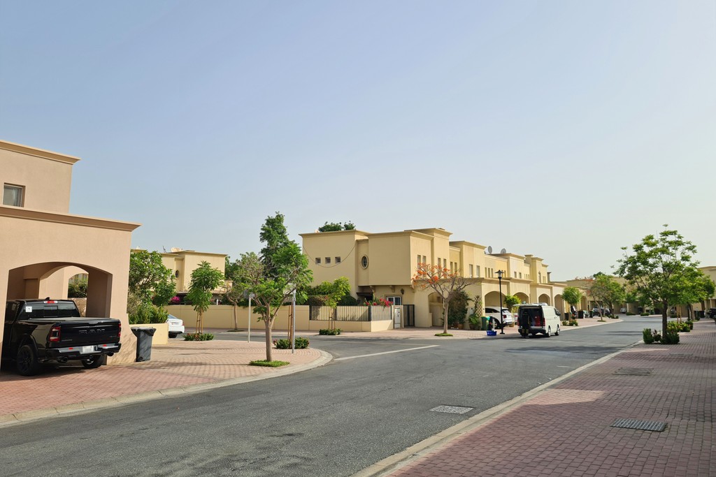 Cars parked along a residential street in the Springs 2 community, with houses visible in the background.