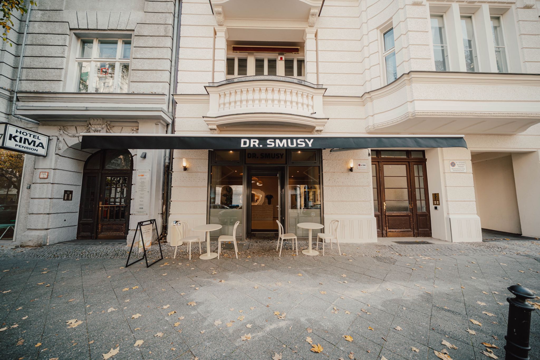 Smiling barista holding green cup at coffee machine
