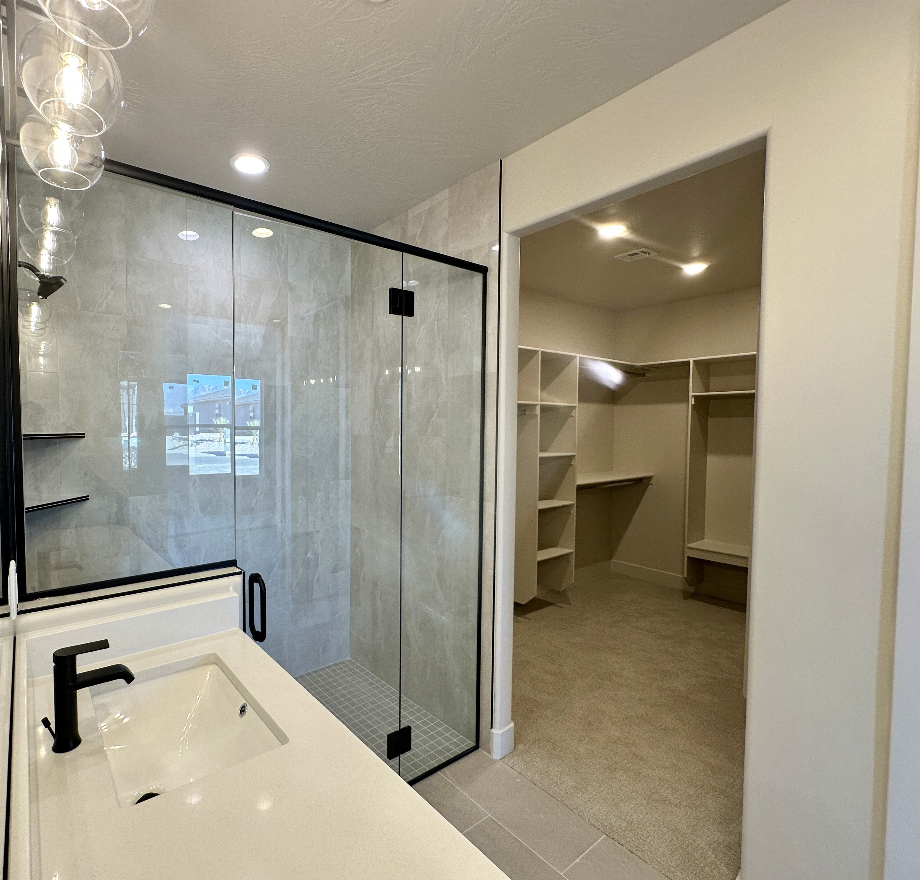 Master bathroom shower at The View at Falcon Ridge in Hurricane, Utah, featuring a walk-in design with tiled walls and modern fixtures.