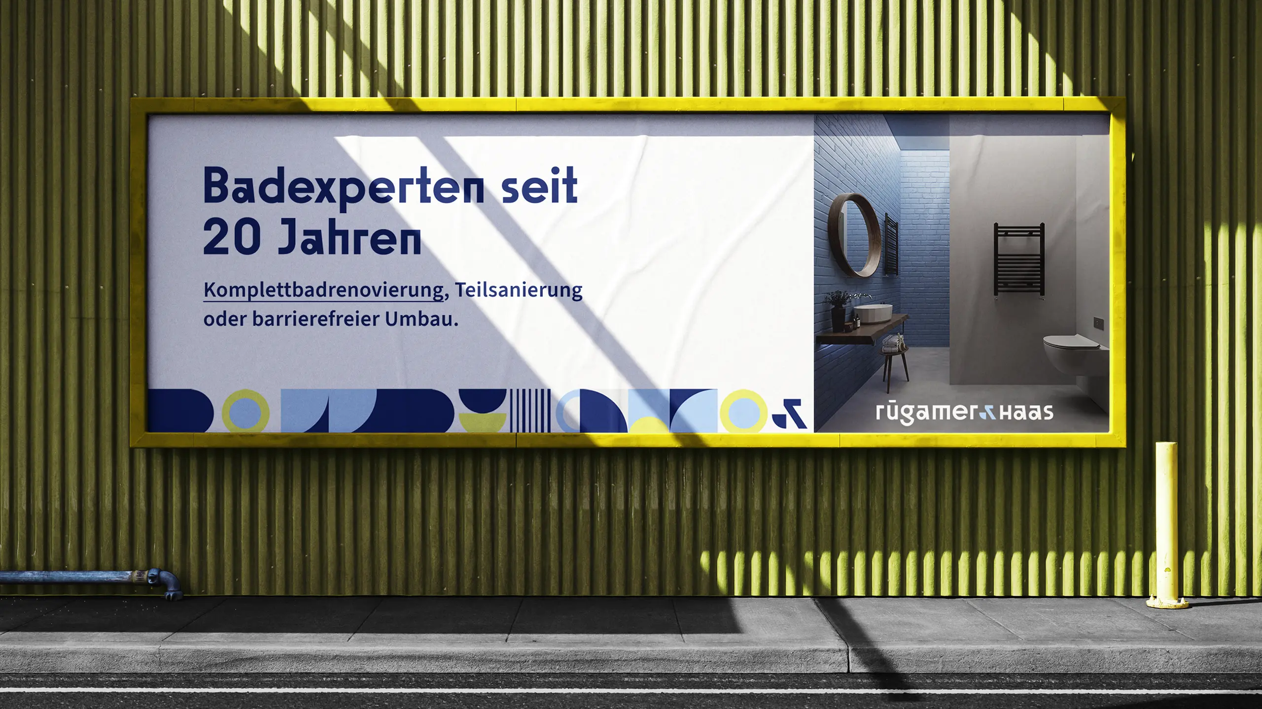 Plakatmockup von Rügamer & Haas an einer gelben Hauswand mit dem Slogan „Badexperten seit 20 Jahren“ und Foto eines modernen Badezimmers.