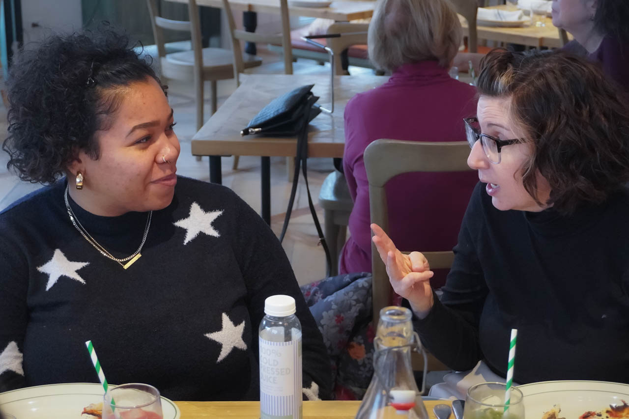 two women talking while seated at a table in a restaurant