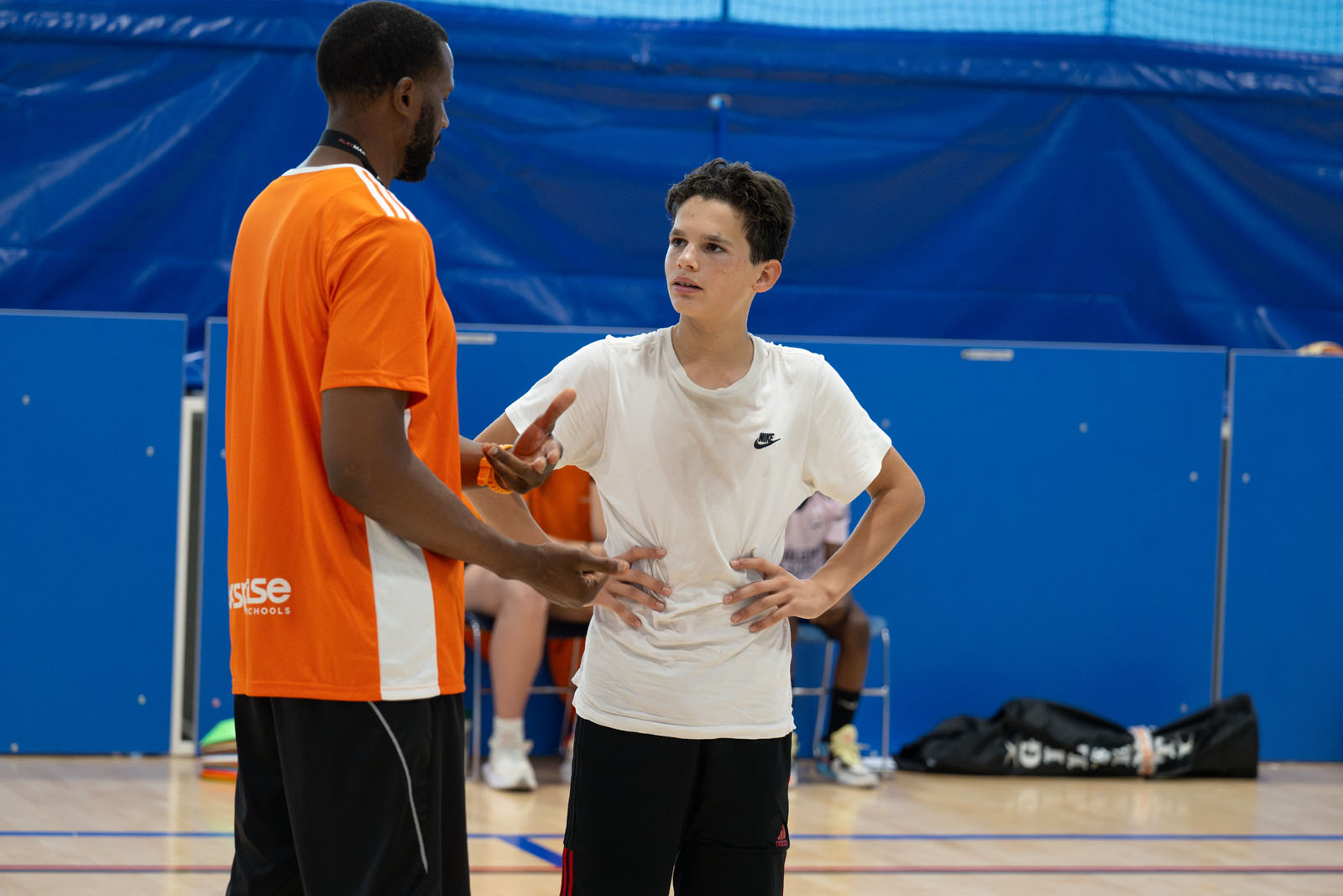A basketball coach talking with a student.