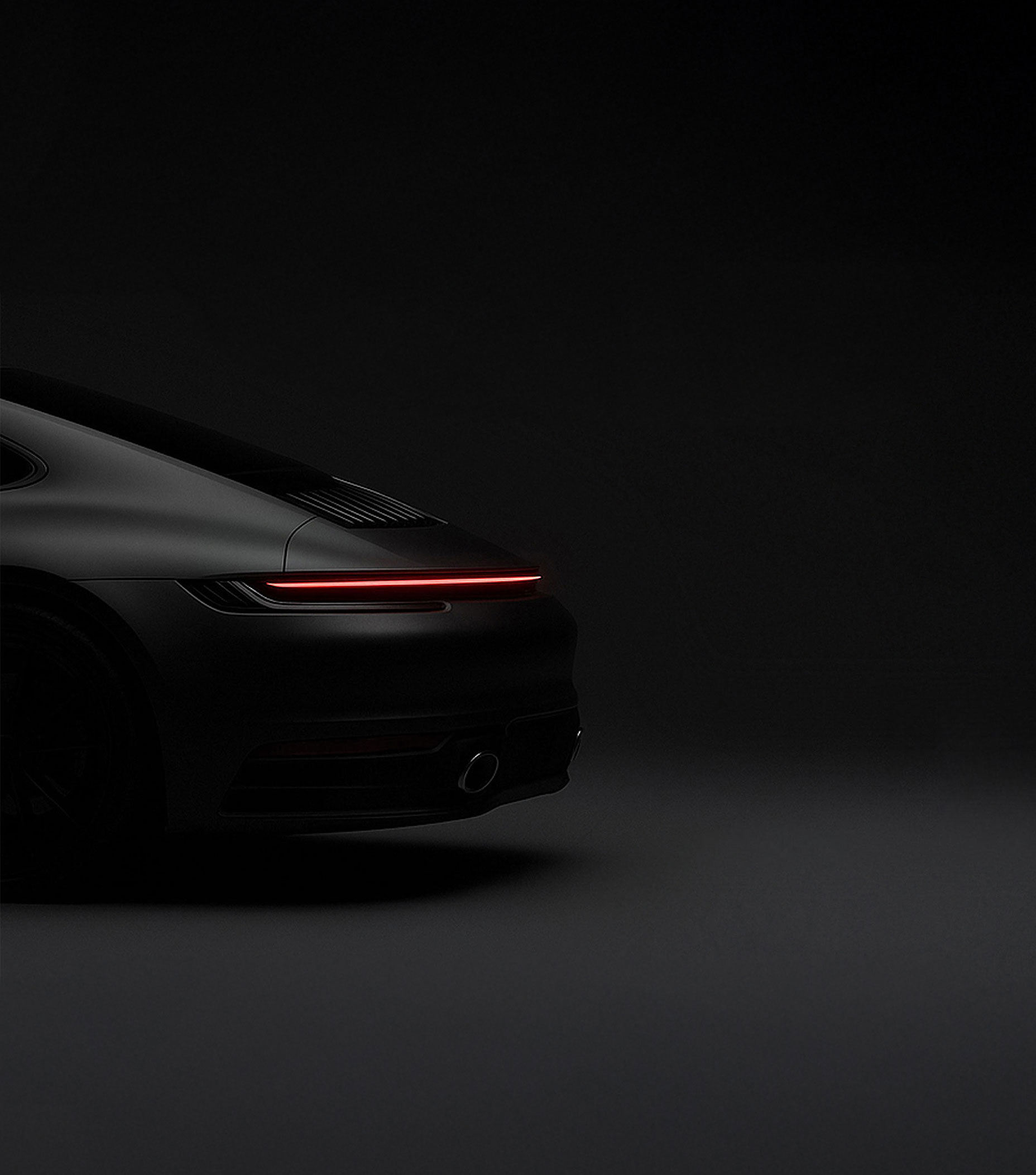Black sports car with taillight on.