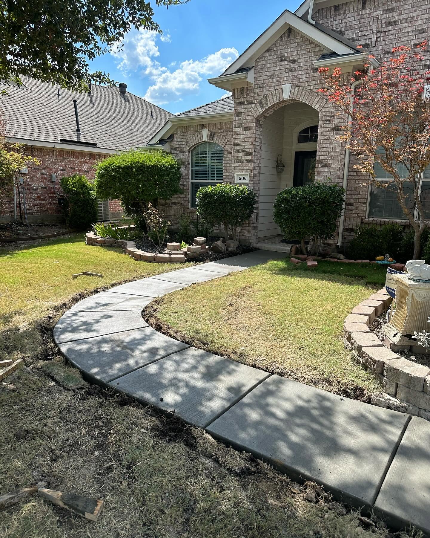 Curved front entry sidewalk installation completed by residential concrete contractors in Dallas.