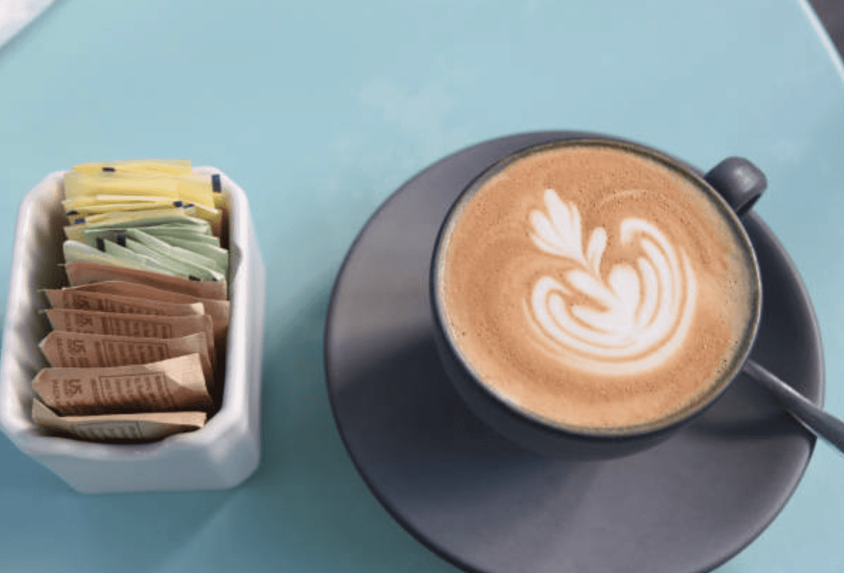 Coffee served in a mug with sweetener to it's side