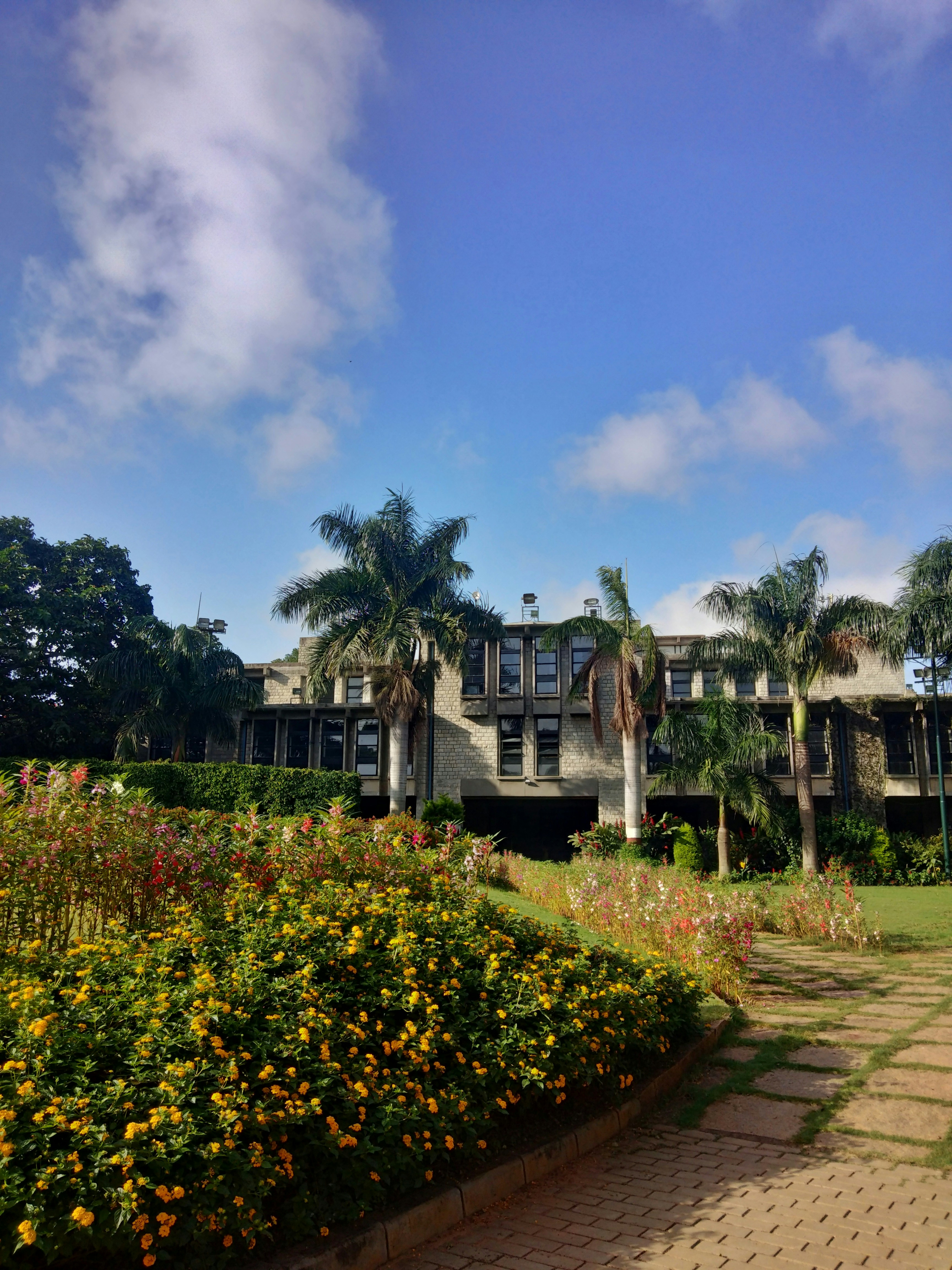 a building with trees and flowers in front of it